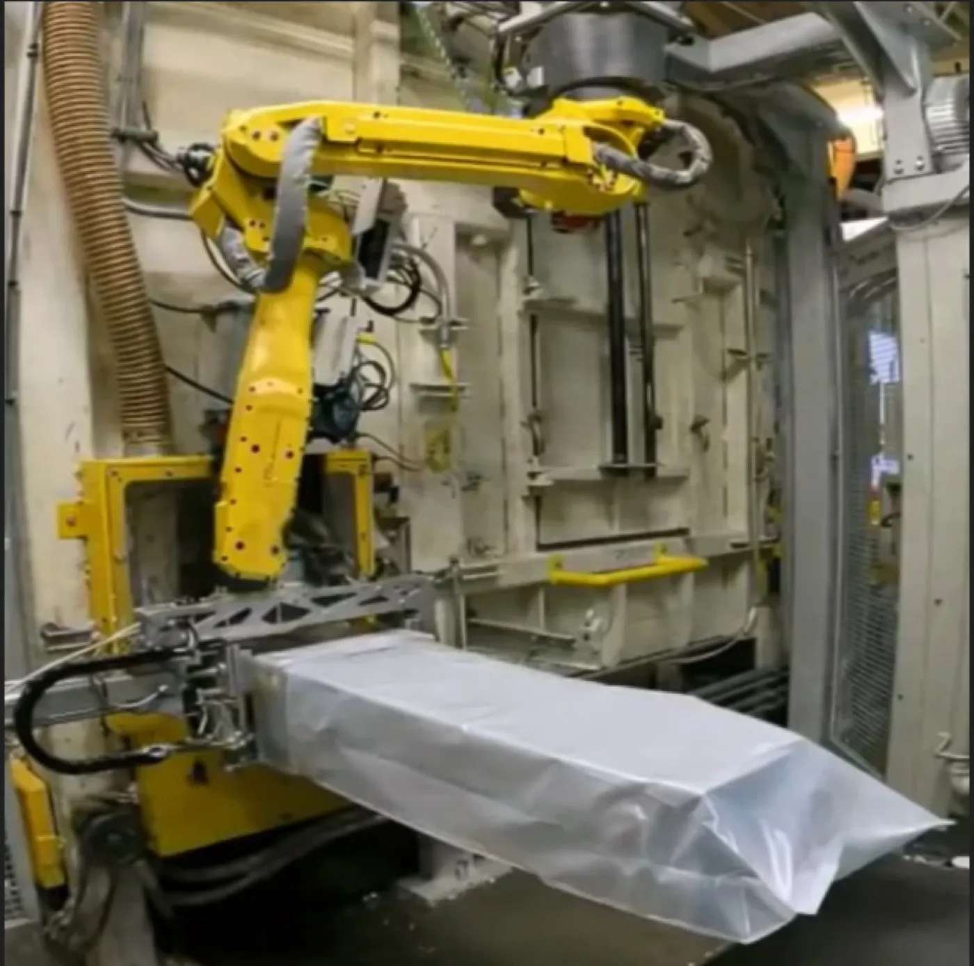 FANUC robot placing a bag on a fill spout on an Automode-integrated line